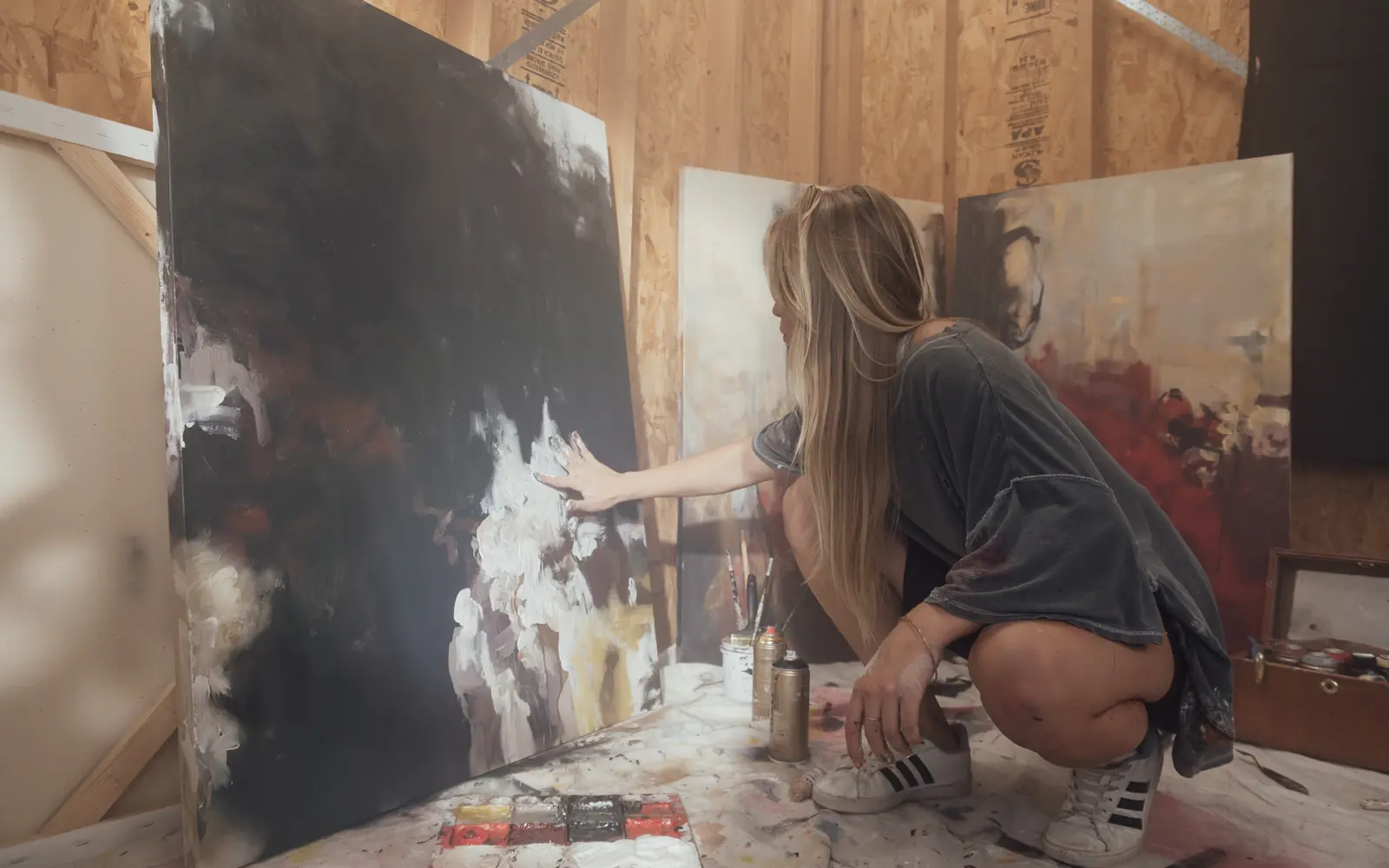 Artist painting a large canvas in her studio