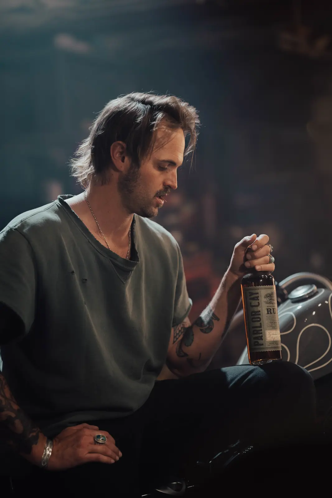 Craftsman holding a product bottle in a dark workshop