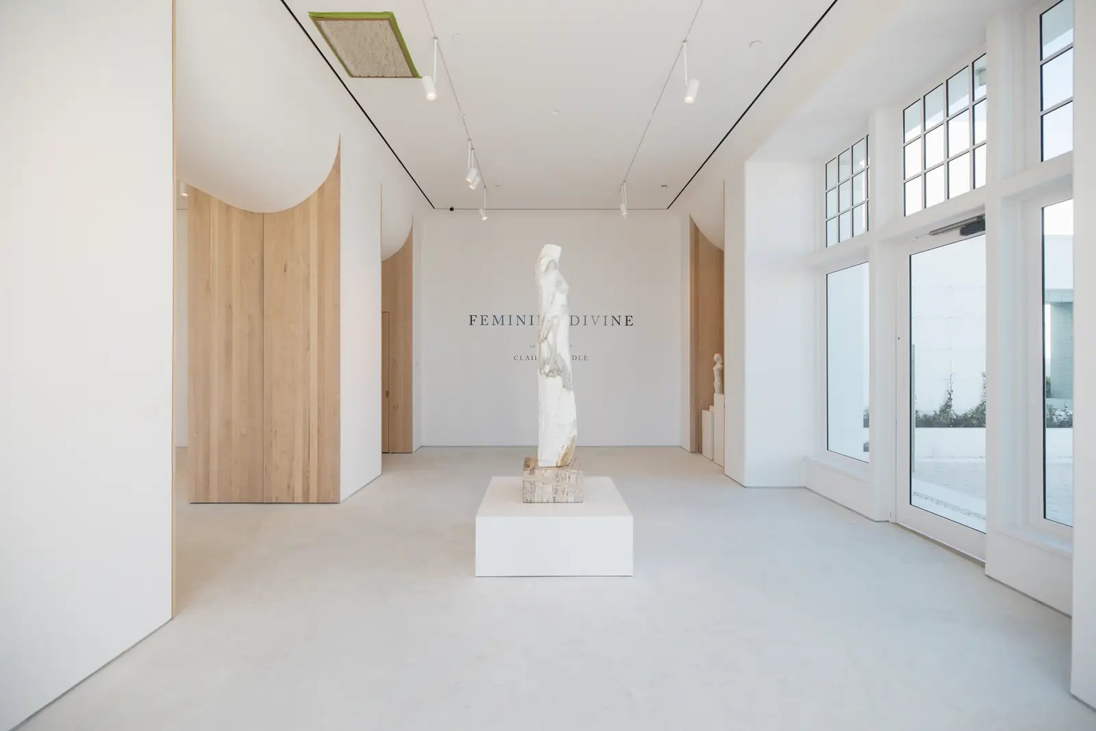 Minimal white gallery interior with sculpture