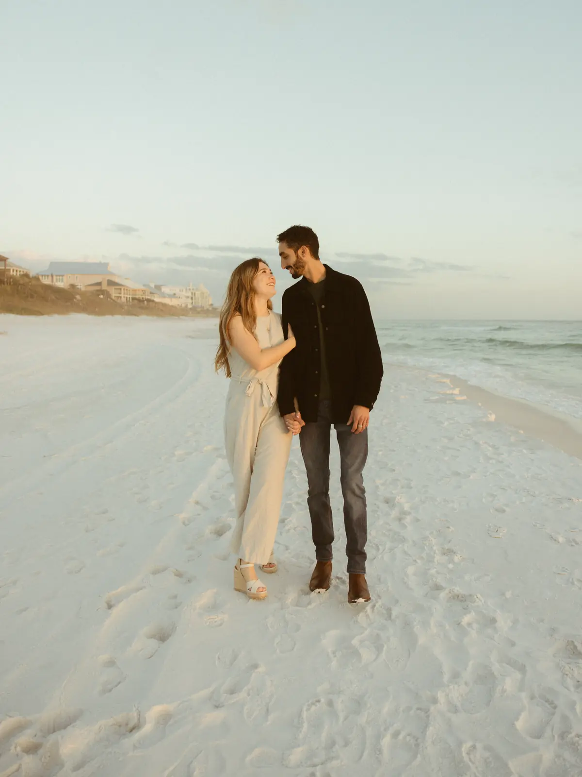 Couple walking hand in hand along the shore
