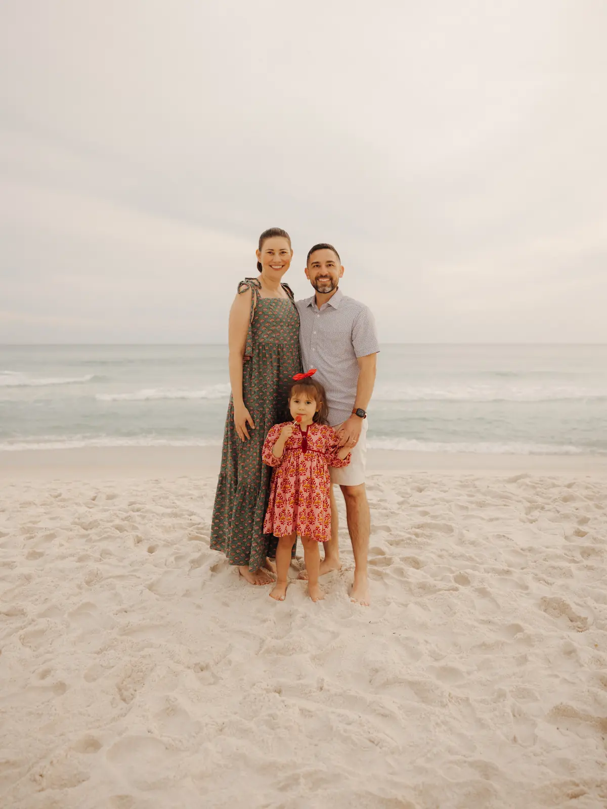 Parents and toddler daughter on the beach at dusk