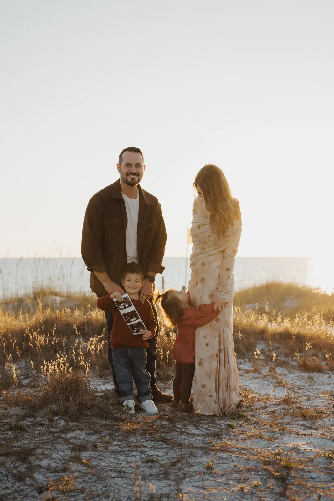 Parents and two children walking through dune grass