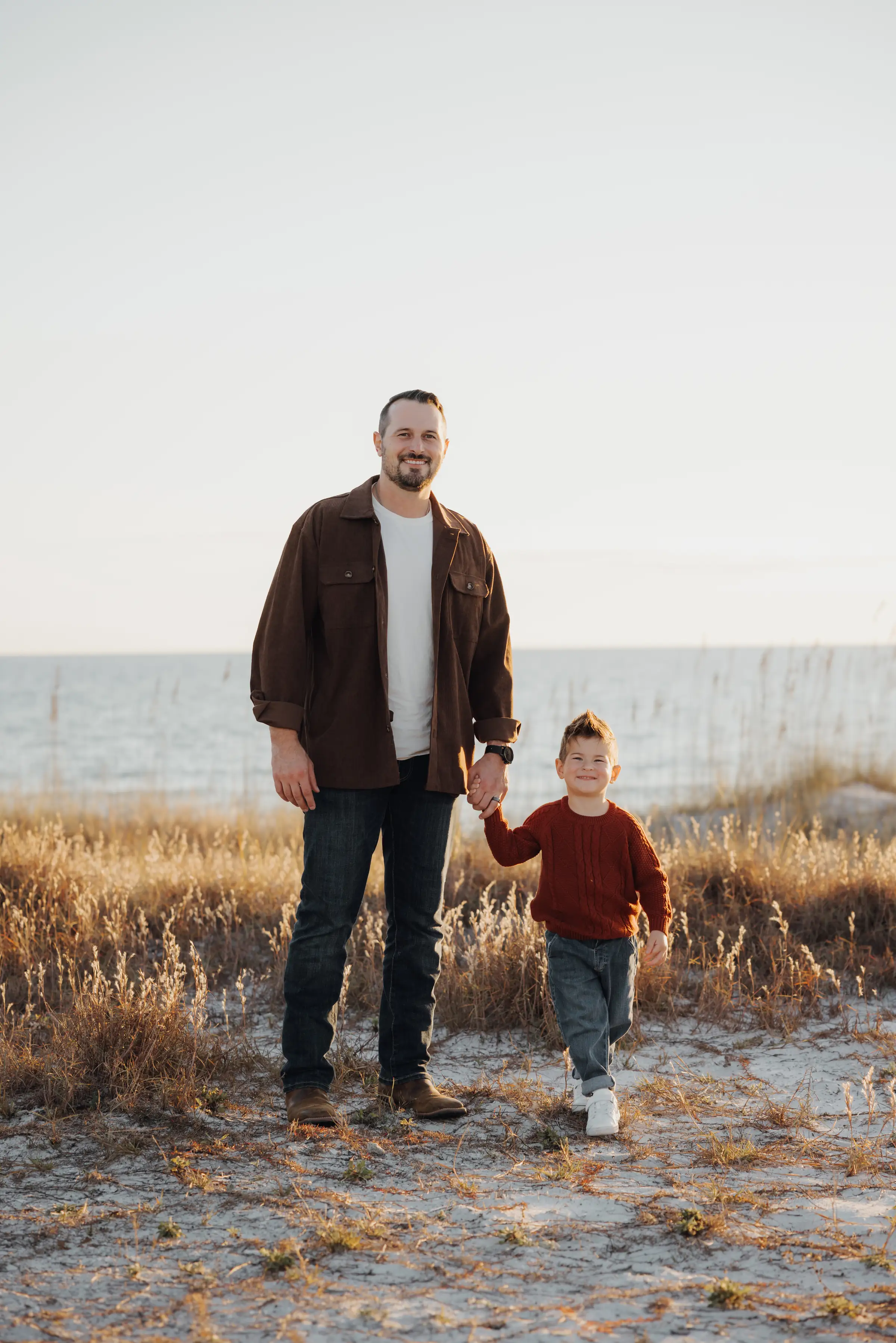 Father and young son in the dune grass