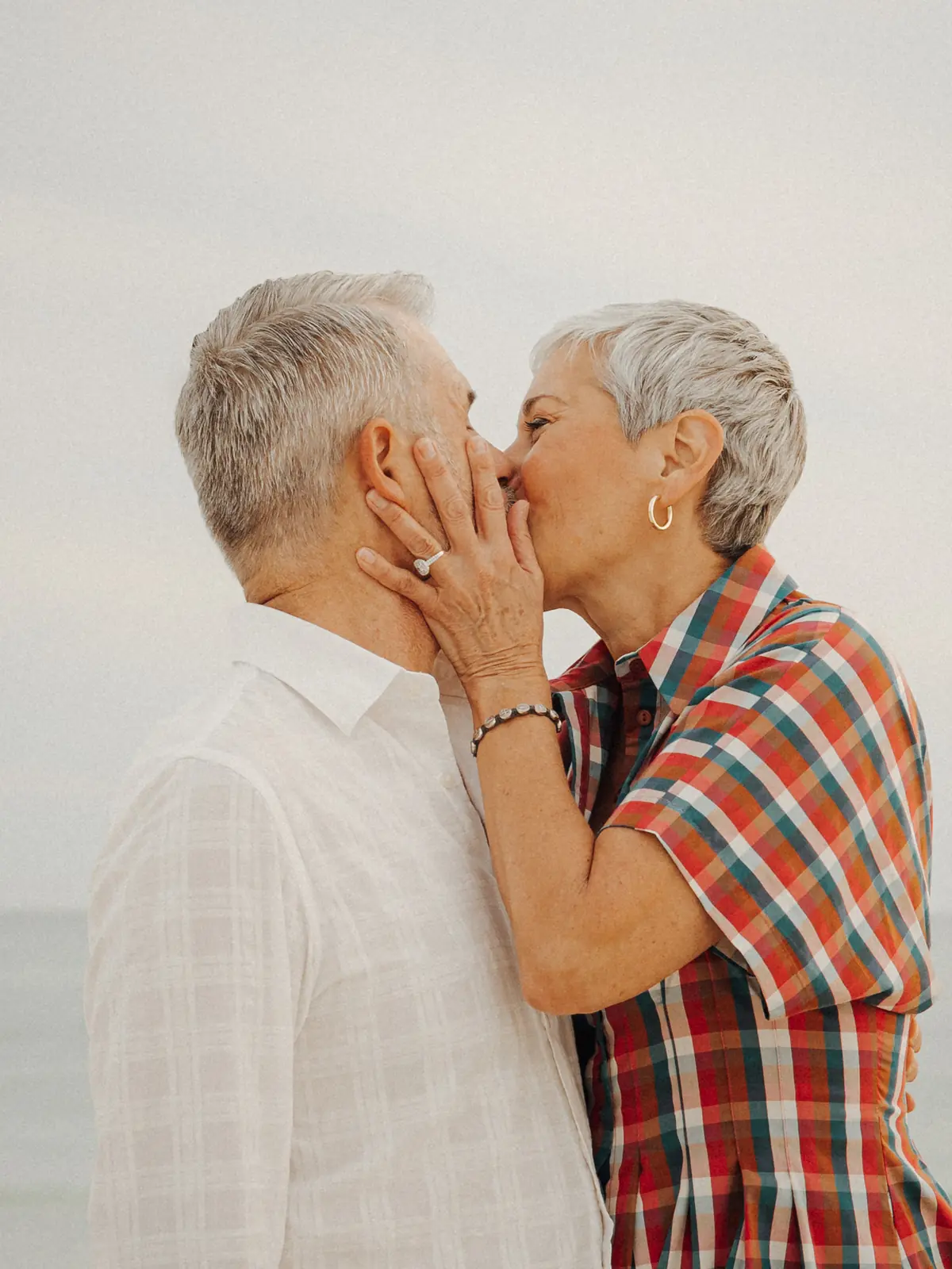 Grandparents sharing a kiss on the beach