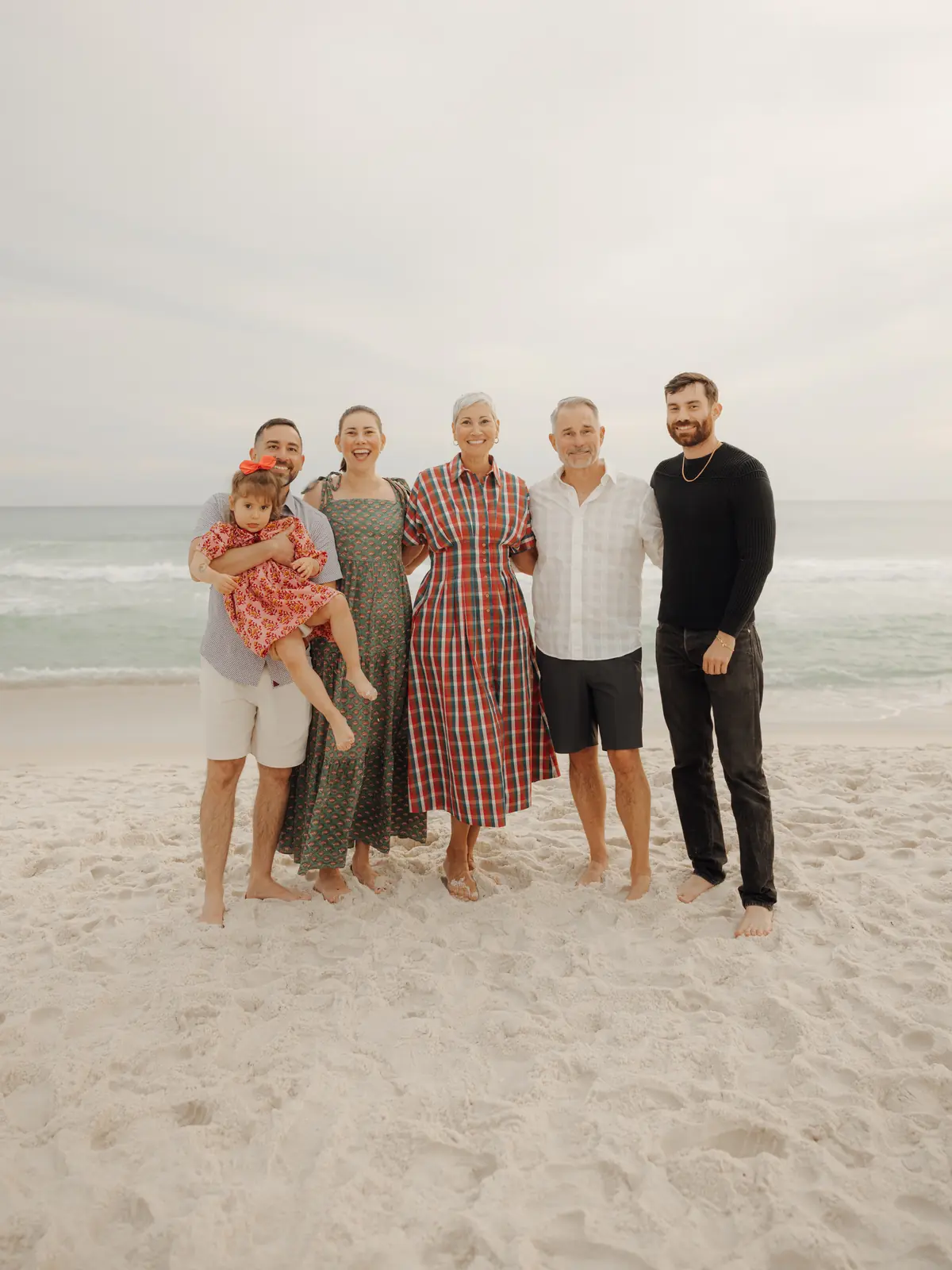 Multi-generation family standing together on the beach